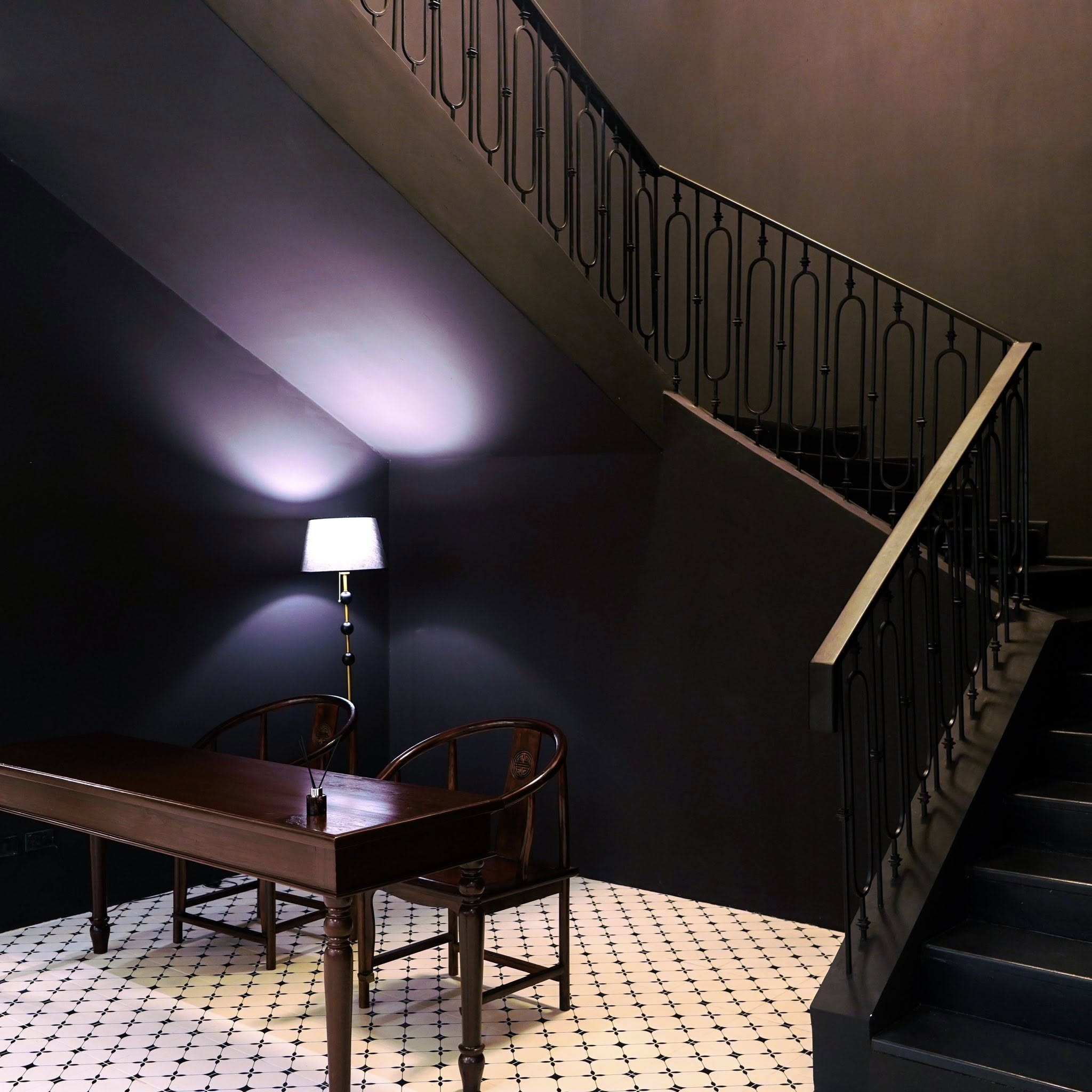 Kebaya Spa treatment room — dark walls, treatment table, ornate staircase